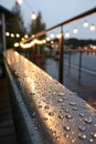 Raindrops on the metal surface in the light colored lights Royalty Free Stock Photo