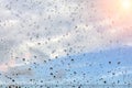 Raindrops on misted window glass against a blue sky. The sun is shining Royalty Free Stock Photo