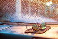 Raindrops and moisture on the car`s front glass with blurred sun Royalty Free Stock Photo