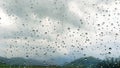 Raindrops rain drops on window with cloudy and rural landscape background