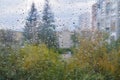 Raindrops on a rainy day on the window pane. Autumn cloudy weather through glass covered with rain drops. Royalty Free Stock Photo