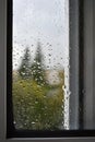 Raindrops on a rainy day on the window pane. Autumn cloudy weather through glass covered with rain drops. Royalty Free Stock Photo