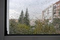 Raindrops on a rainy day on the window pane. Autumn cloudy weather through glass covered with rain drops. Royalty Free Stock Photo