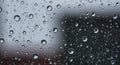 Raindrops are scattered across a glass window, creating a pattern of various sizes. Th Royalty Free Stock Photo