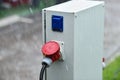 Raindrops are seen on industrial electric plug during rain