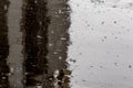 Raindrops on shiny wet flat asphalt background with selective focus.