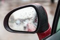 Raindrops on side rear view mirror in rain