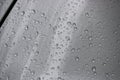 Raindrops on the silvery surface of the car. Selective focus