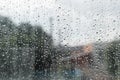 Raindrops on the surface of window, cloudy rainy weather, defocus city background Royalty Free Stock Photo