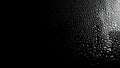 Raindrops on the surface of the window panes with a black background. Natural rain pattern on the glass. Light Royalty Free Stock Photo