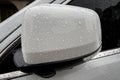Raindrops on white car side rear-view mirror Royalty Free Stock Photo