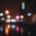 Raindrops on a window create a watery texture, distorting the vibrant bokeh of multicolored city lights in the background