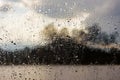 Raindrops on a window with a defocused lake landscape in the background Royalty Free Stock Photo