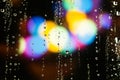 Rain drops on the window. Colorful street lights on the rain. Blurred abstract background. Royalty Free Stock Photo