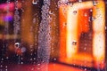 Rain drops on the window. Colorful street lights on the rain. Blurred abstract background. Royalty Free Stock Photo