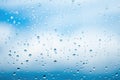 Raindrops on window glass against blue sky with white clouds. Place for text banner Royalty Free Stock Photo