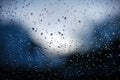 Raindrops on window glass on blue background Royalty Free Stock Photo