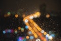 Raindrops on window glass, blurred bokeh city lights at night, dark abstract background Royalty Free Stock Photo