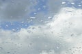 Raindrops on the window glass. Clear blue sky with white clouds. Blurred background Royalty Free Stock Photo