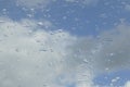 Raindrops on the window glass. Clear blue sky with white clouds. Royalty Free Stock Photo