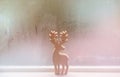 Raindrops on window glass and deer sculpture wood background Royalty Free Stock Photo