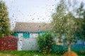 Raindrops on a window glass of a dwelling, where part of the street is seen in the background Royalty Free Stock Photo