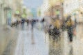 Raindrops on window glass, people walk on road in rainy day, blurred motion abstract background. Concept of shopping Royalty Free Stock Photo