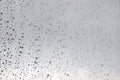 Raindrops on a window glass in rainy cloudy day against a gray sky. Autumn, depressive, rainy weather Royalty Free Stock Photo