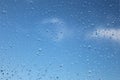 Raindrops on a window pain with a blue sky background. Royalty Free Stock Photo