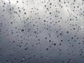 Raindrops on a window pane, on a background of heavily cloudy sky