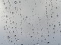 Raindrops on a window pane, on a background of heavily cloudy sky