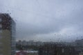 raindrops on the window pane, clouds behind the glass, raining, city roofs behind the raindrops Royalty Free Stock Photo