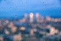 Raindrops on a window pane of glass with blurred background of River Thames and City of London