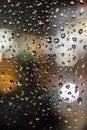 Raindrops on a window pane in the light of evening lights Royalty Free Stock Photo