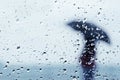 Raindrops on window with person with umbrella Royalty Free Stock Photo