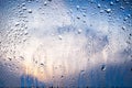 Raindrops on the window. Water drops on glass. Abstract background. Blue sky with clouds. Texture of drops. Selective focus Royalty Free Stock Photo