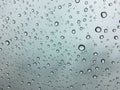 The raindrops on the windscreen or windshield or car glass. View from the inside of the car with a grey sky background. Adjust the Royalty Free Stock Photo