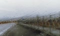 Raindrops on the windshield of the car. View from the inside of the road Royalty Free Stock Photo