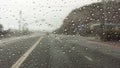 Raindrops on windshield while driving down highway