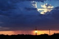 It is raining against the backdrop of the power line tower at sunset. Royalty Free Stock Photo