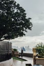 Raining in Park that near the Coast with a Man Holding Umbrella and Seeing Seascape and Cityscape of George Town, Penang, Malaysia Royalty Free Stock Photo