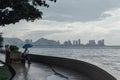 Raining in Park that near the Coast with a Man Holding Umbrella and Seeing Seascape and Cityscape of George Town, Penang, Malaysia Royalty Free Stock Photo