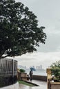 Raining in Park that near the Coast with a Man Holding Umbrella and Seeing Seascape and Cityscape of George Town, Penang, Malaysia Royalty Free Stock Photo