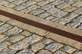 Rainwater drainage grid in a cobbled pavement