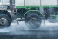 Rainwater spraying from motion truck wheels. city road during he Royalty Free Stock Photo