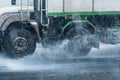 Rainwater spraying from motion truck wheels. city road during he Royalty Free Stock Photo