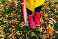 Yellow raincoat. Rubber pink boots against. Conceptual image of legs in boots on green grass Royalty Free Stock Photo