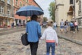Woman with child girl walking under an umbrella in street Royalty Free Stock Photo