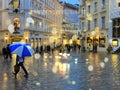 Rainy Christmas city evening people walking under umbrella evening street in medieval town blur light lamp Tallinn old town tra