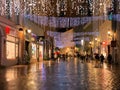 Rainy Christmas in the City Tallinn Old town street night light people walking with umbrellas rain drops reflection on window s